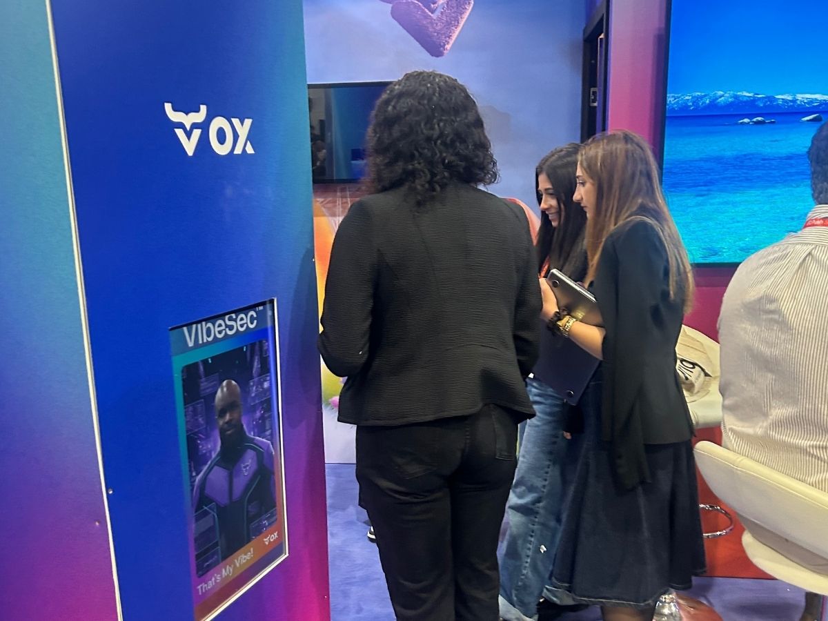 Delegates moving past and engaging with the VOX Security AI photo booth on the exhibition floor