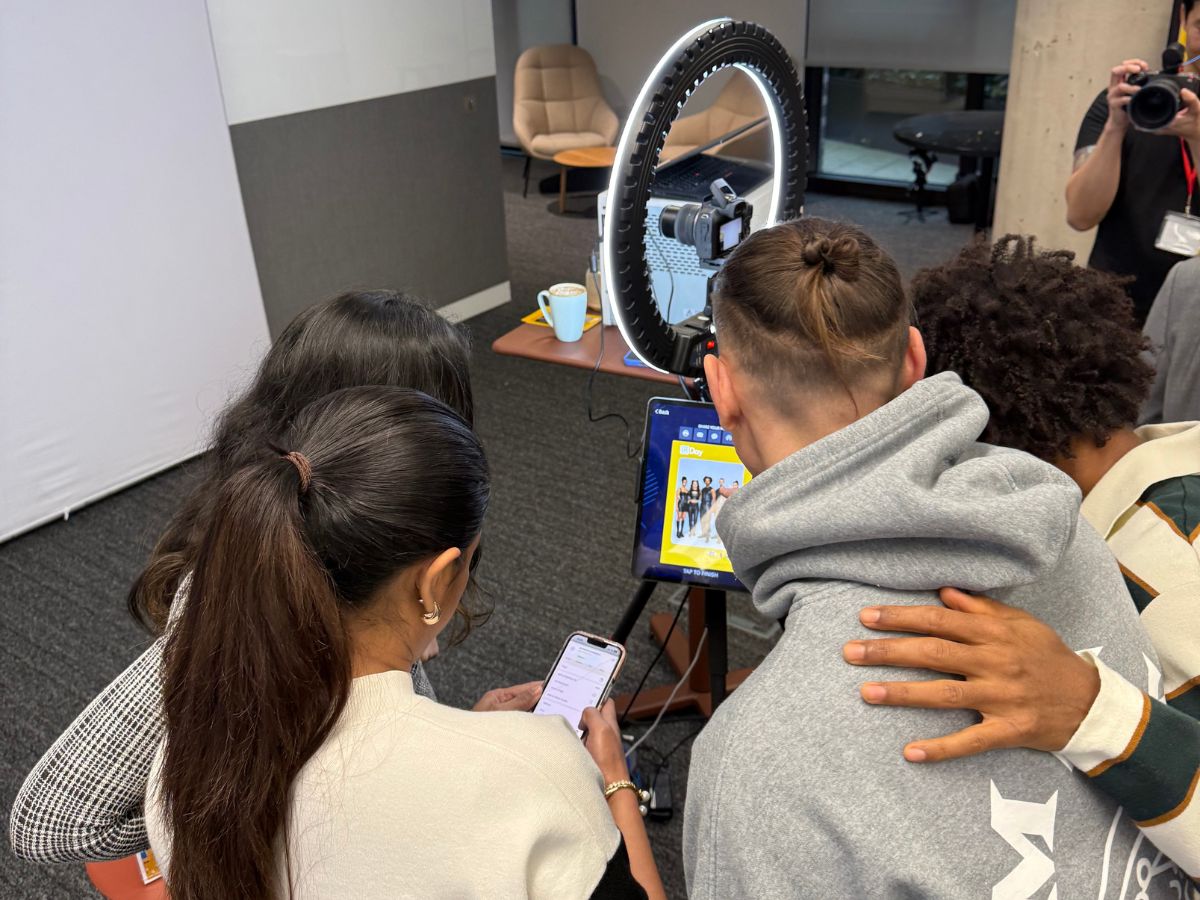 LinkedIn event guests reviewing their branded AI portraits at the ring-light photo station