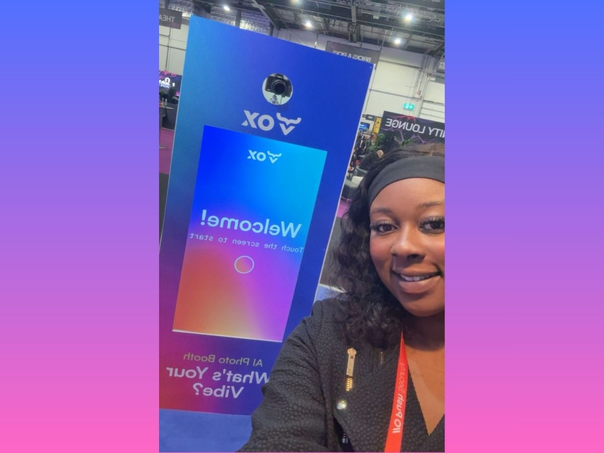 Delegate taking a selfie beside the branded VOX Security AI photo booth screen