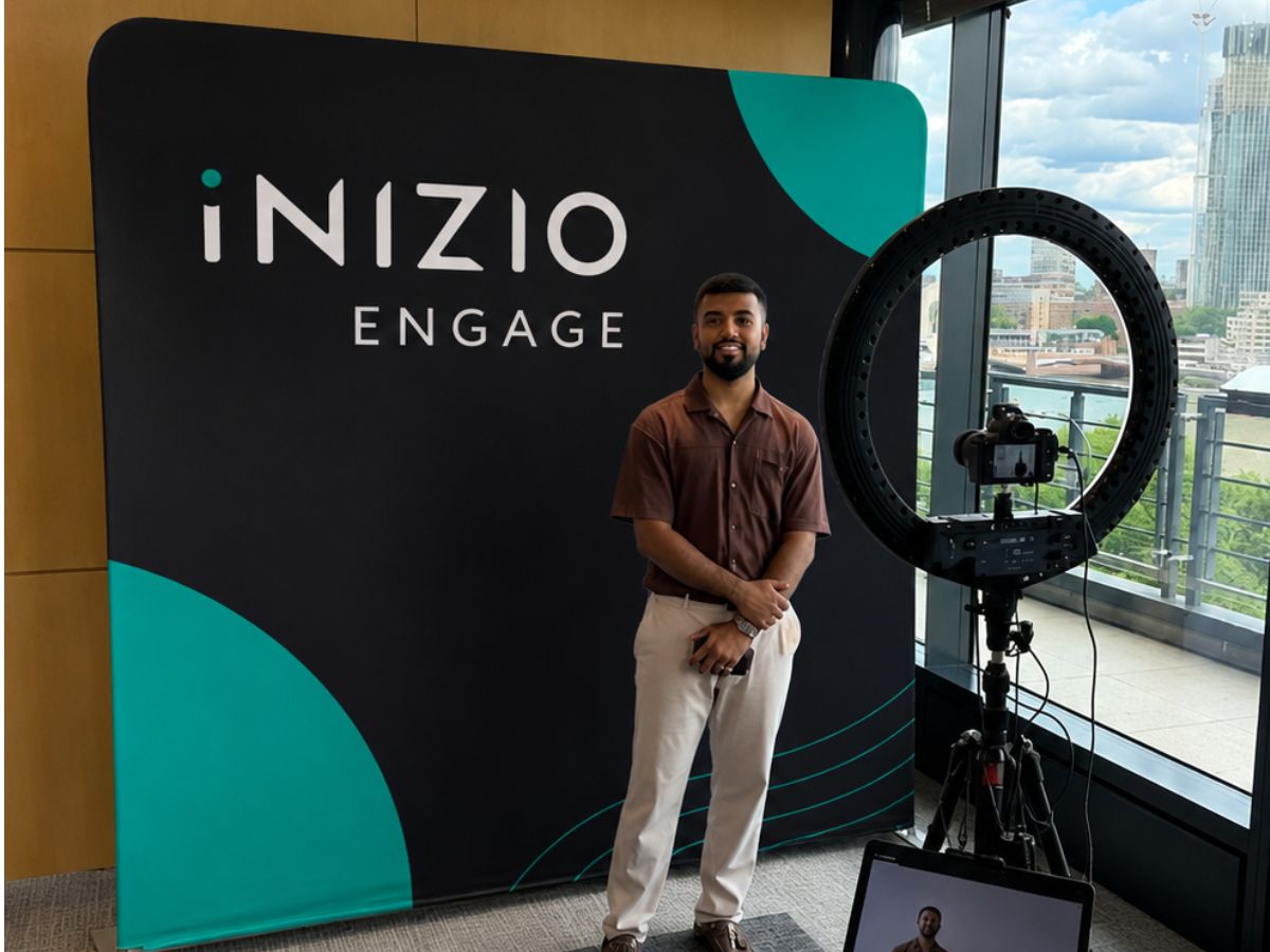 Guest standing in front of a premium branded fabric backdrop with ring light selfie pod in a London office