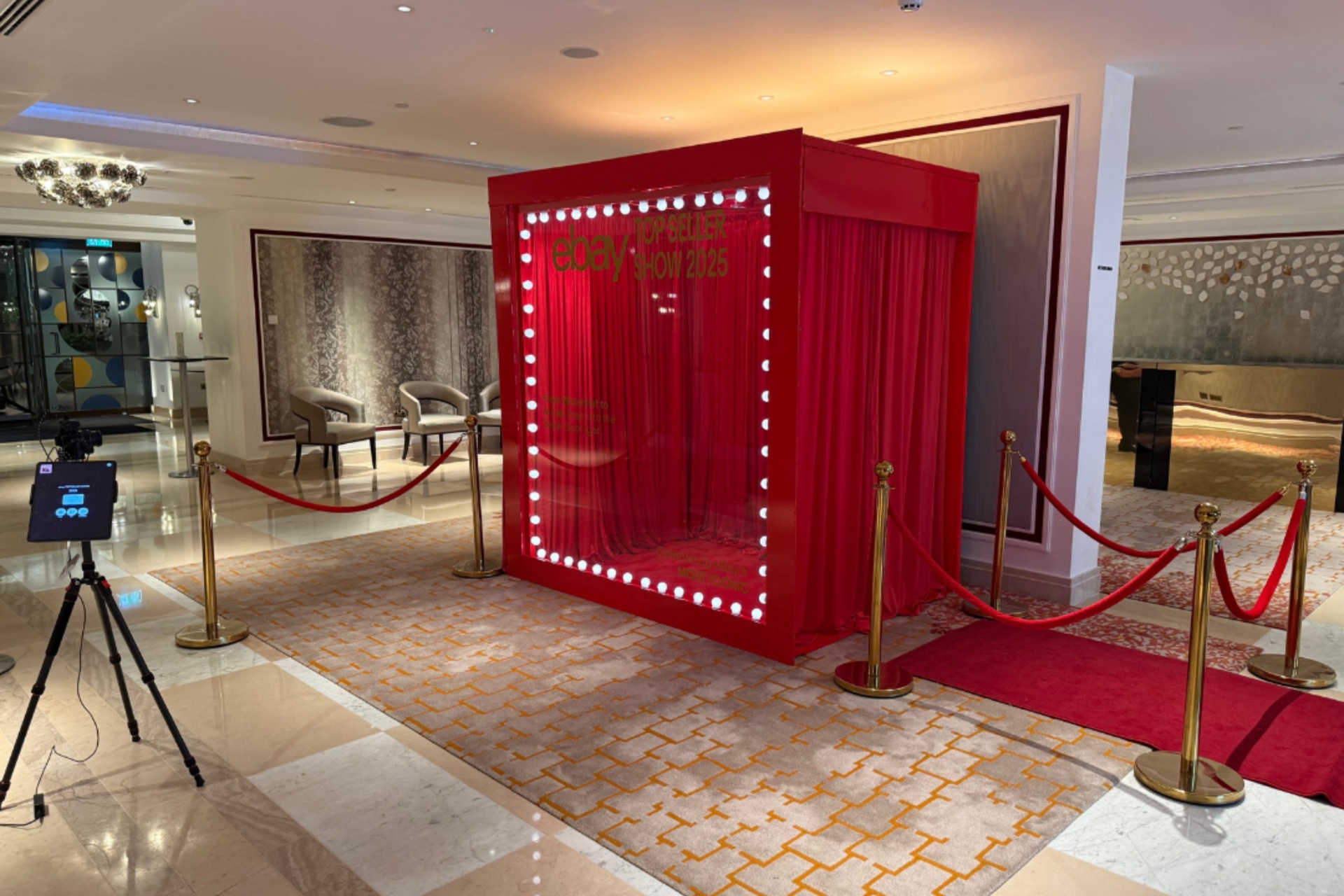 A confident guest poses in front of a bespoke magazine cover installation at a luxury London corporate event